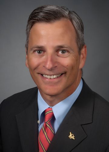 Ira Nash, MD, wearing a blue shirt and red and gold tie